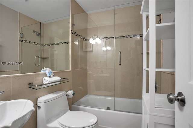 full bathroom featuring bath / shower combo with glass door, toilet, and sink