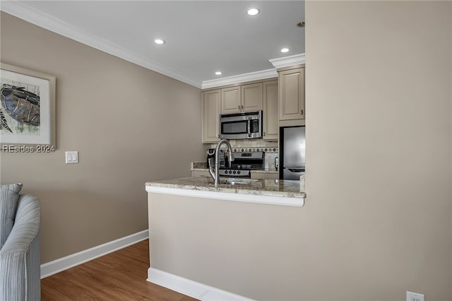 kitchen featuring tasteful backsplash, ornamental molding, appliances with stainless steel finishes, dark hardwood / wood-style flooring, and cream cabinetry