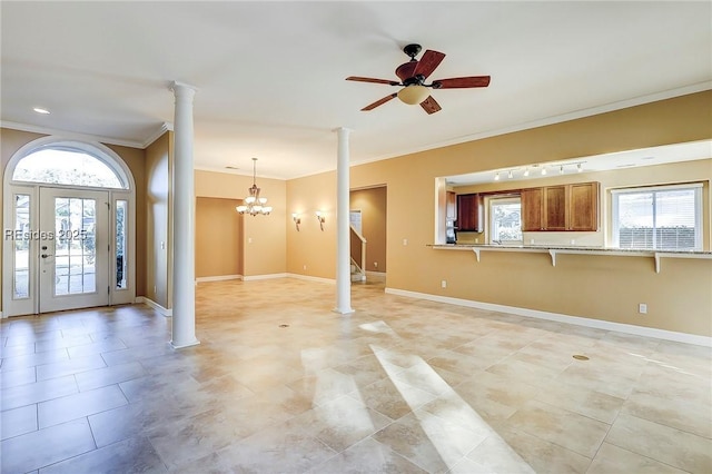 entrance foyer featuring decorative columns, crown molding, and ceiling fan with notable chandelier