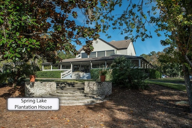 rear view of house featuring a sunroom