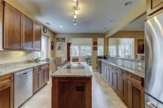 kitchen featuring light stone counters, a kitchen island, and appliances with stainless steel finishes