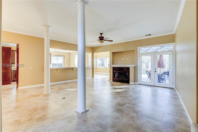 unfurnished living room with ceiling fan, crown molding, a healthy amount of sunlight, and ornate columns