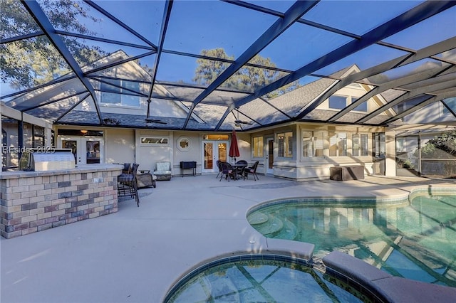 view of swimming pool with a bar, a patio, glass enclosure, and an in ground hot tub