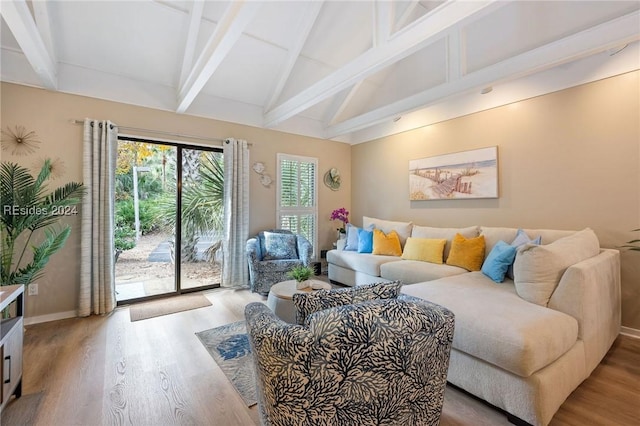 living room with vaulted ceiling with beams and light hardwood / wood-style flooring