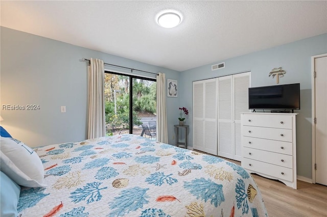 bedroom featuring light hardwood / wood-style flooring, a textured ceiling, a closet, and access to outside