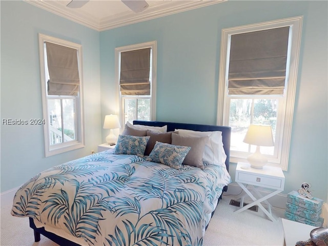 carpeted bedroom with multiple windows, ornamental molding, and ceiling fan