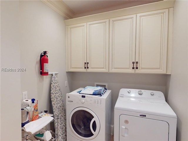 clothes washing area featuring crown molding, independent washer and dryer, and cabinets