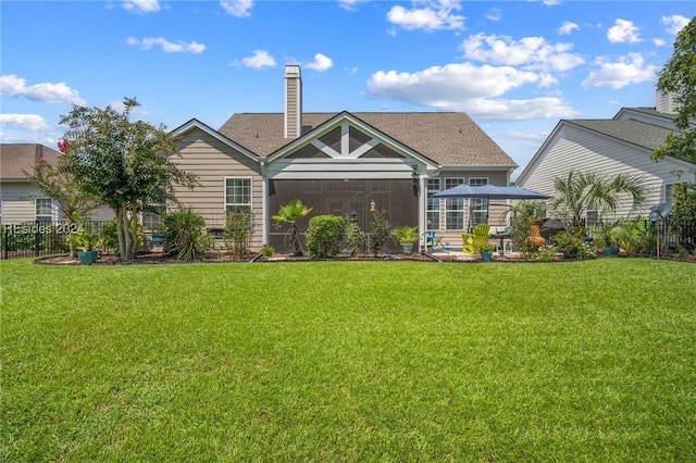 back of property with a yard and a sunroom