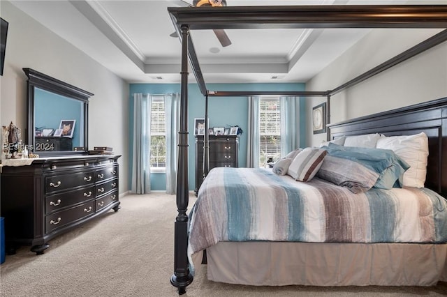 bedroom with light carpet, a tray ceiling, and crown molding