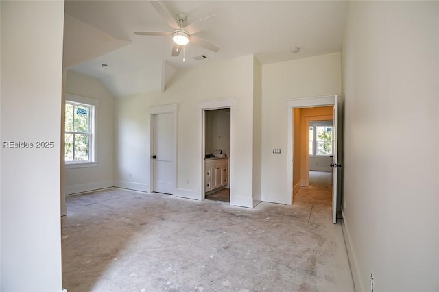 unfurnished bedroom with vaulted ceiling, connected bathroom, and ceiling fan