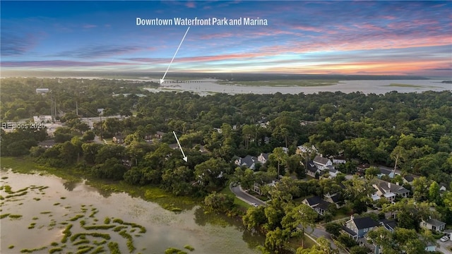 aerial view at dusk featuring a water view