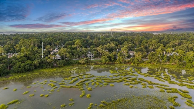 aerial view at dusk featuring a water view