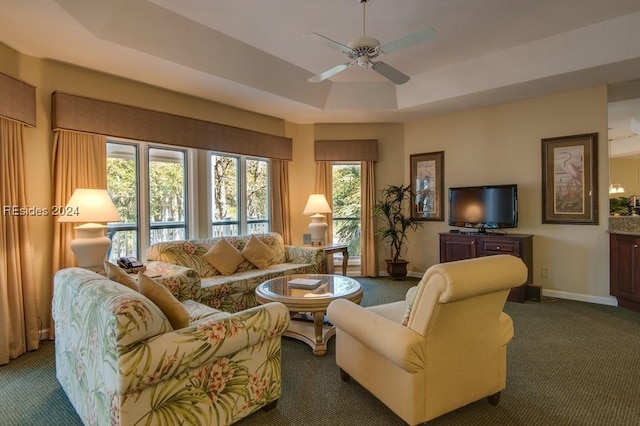 carpeted living room featuring a raised ceiling and ceiling fan