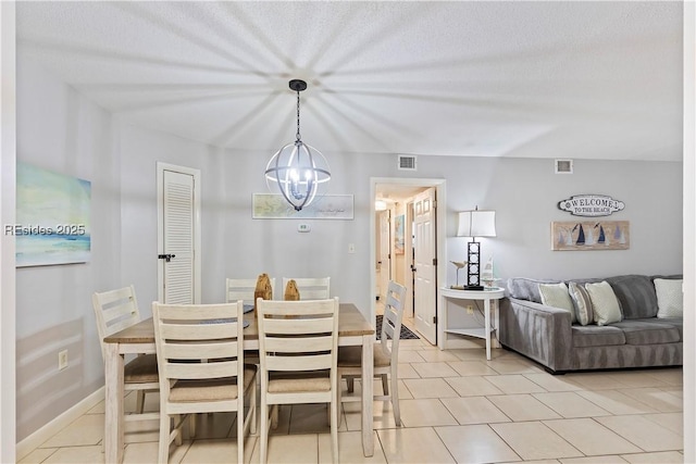 dining room with light tile patterned floors and a chandelier