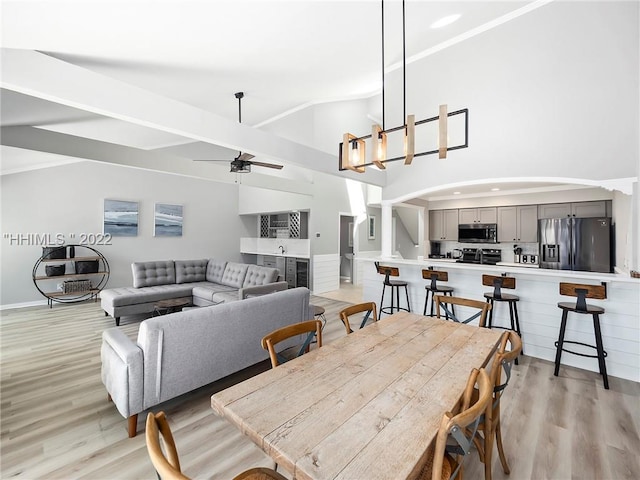 dining area with ceiling fan, lofted ceiling, and light hardwood / wood-style floors