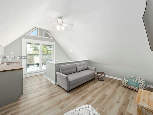 additional living space with lofted ceiling, sink, light hardwood / wood-style flooring, and ceiling fan