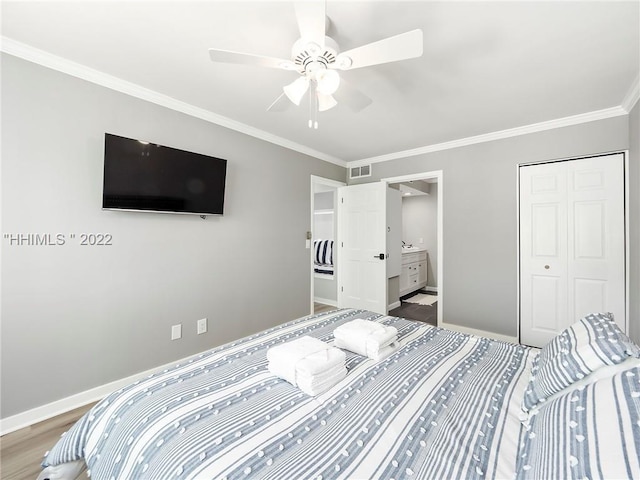 bedroom featuring ensuite bathroom, wood-type flooring, ornamental molding, ceiling fan, and a closet