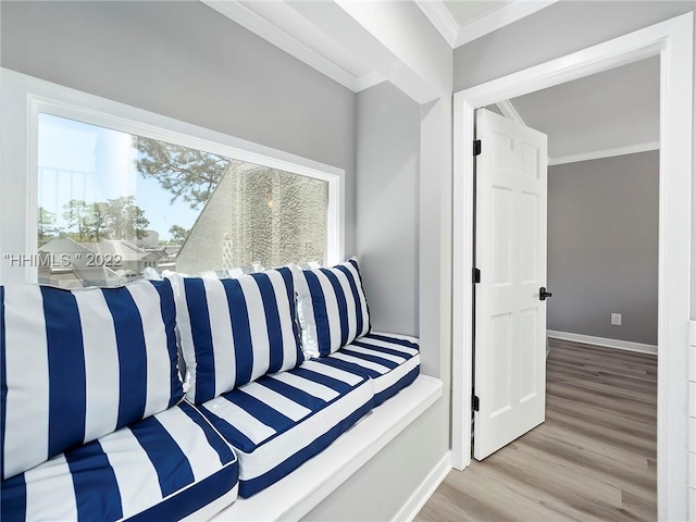 sitting room with ornamental molding and light wood-type flooring