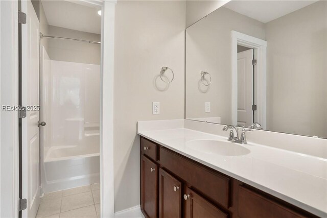 bathroom featuring tile patterned flooring, vanity, and  shower combination