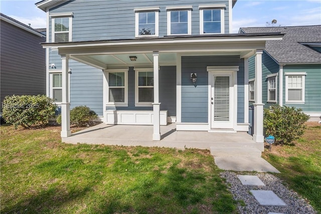 property entrance featuring a porch and a lawn