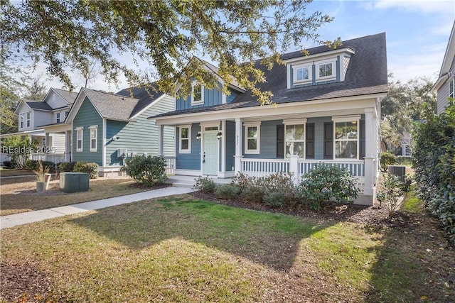 new england style home featuring cooling unit, a porch, and a front lawn