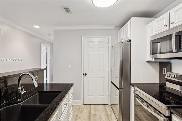 kitchen featuring sink, crown molding, dark stone countertops, stainless steel appliances, and white cabinets