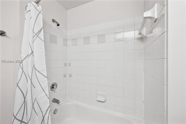 bathroom featuring shower / bathtub combination with curtain and a textured ceiling