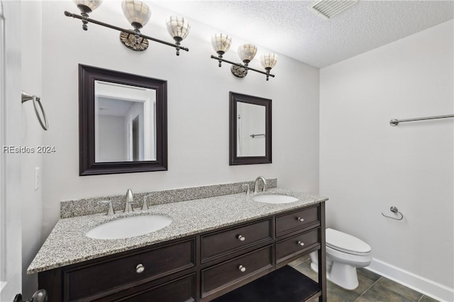 bathroom with tile patterned floors, toilet, vanity, and a textured ceiling