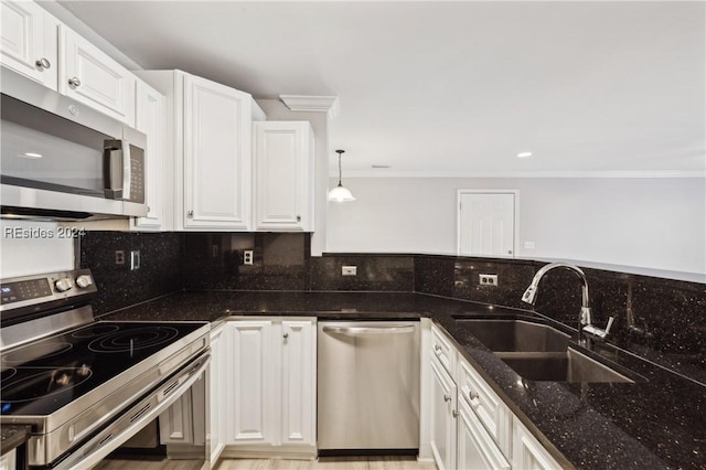 kitchen featuring sink, dark stone countertops, hanging light fixtures, stainless steel appliances, and white cabinets