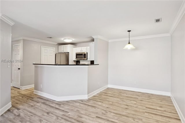 kitchen featuring crown molding, pendant lighting, stainless steel appliances, light hardwood / wood-style floors, and white cabinets