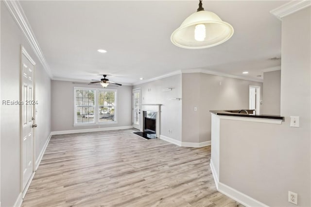 unfurnished living room with light hardwood / wood-style flooring, a high end fireplace, ornamental molding, and ceiling fan