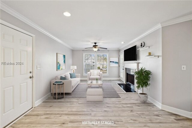 living room with crown molding, ceiling fan, and light hardwood / wood-style floors