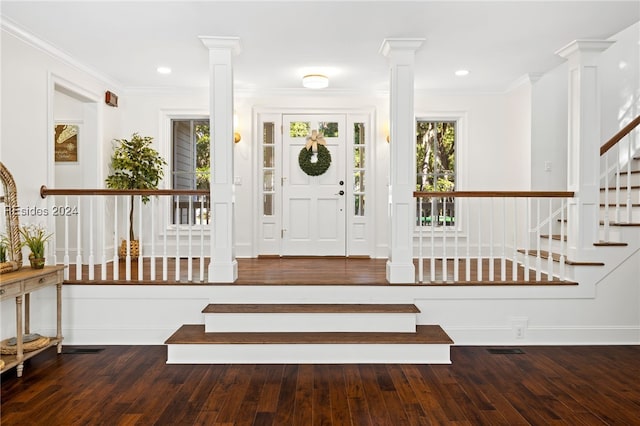 foyer featuring decorative columns, wood-type flooring, and ornamental molding