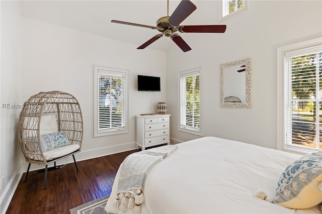 bedroom featuring multiple windows, dark hardwood / wood-style flooring, and ceiling fan