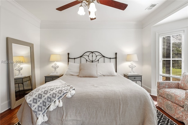 bedroom with ornamental molding, dark hardwood / wood-style floors, and ceiling fan