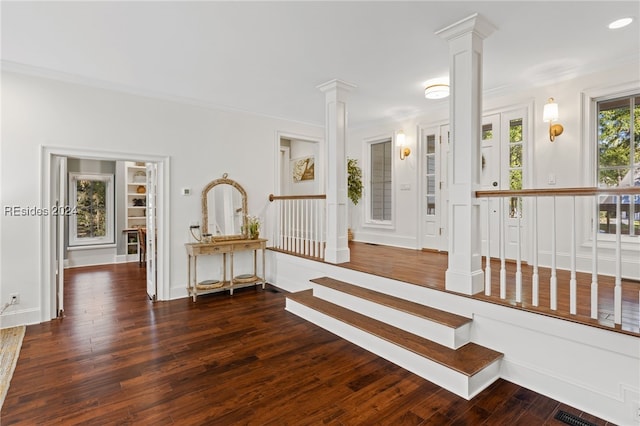 stairs featuring wood-type flooring, ornamental molding, and ornate columns