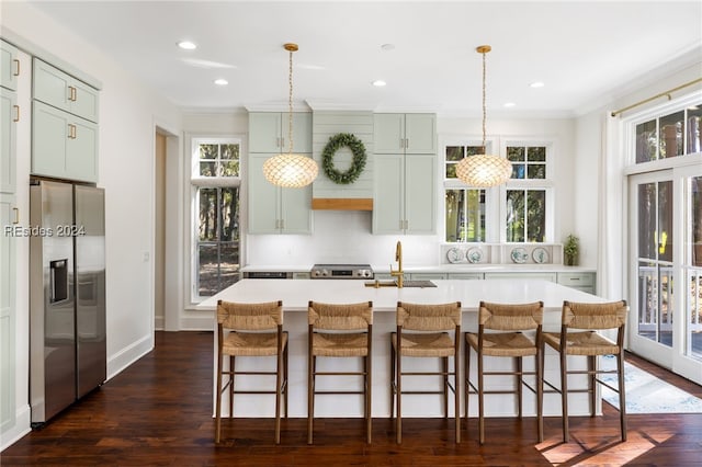 kitchen with sink, a kitchen island with sink, stainless steel refrigerator with ice dispenser, dark hardwood / wood-style flooring, and decorative light fixtures