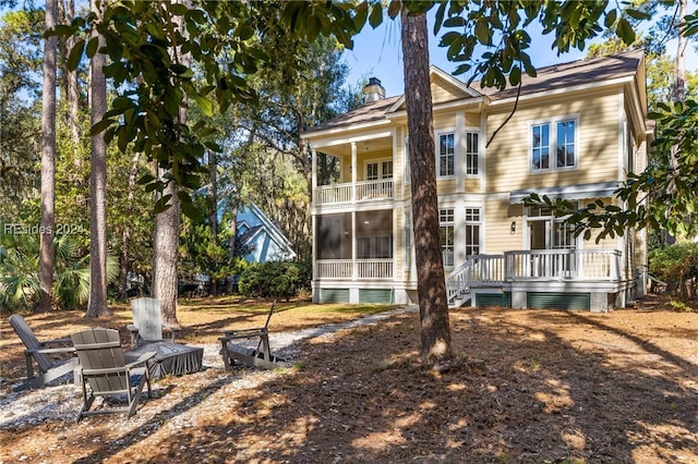 rear view of house featuring a balcony and a deck