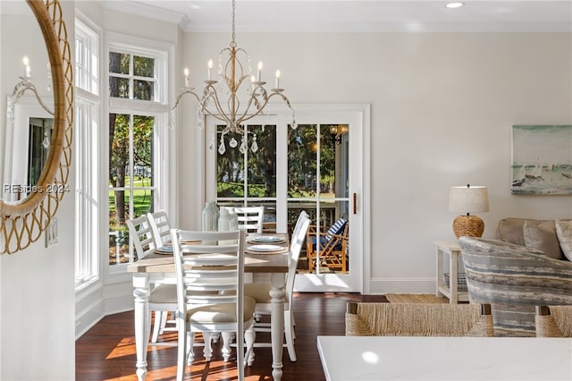 dining room with an inviting chandelier, crown molding, dark wood-type flooring, and plenty of natural light