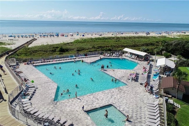 view of pool featuring a water view and a view of the beach