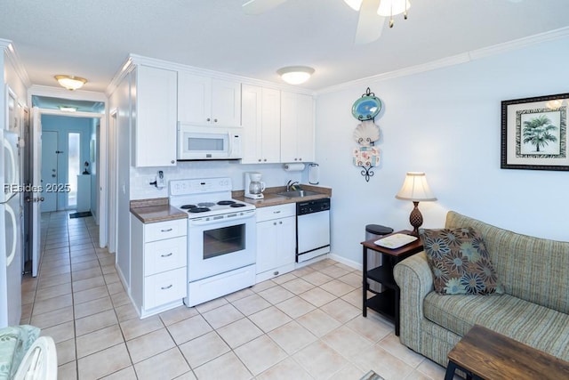 kitchen featuring light tile patterned flooring, sink, white cabinets, ornamental molding, and white appliances