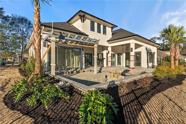 rear view of property featuring a pergola and a patio