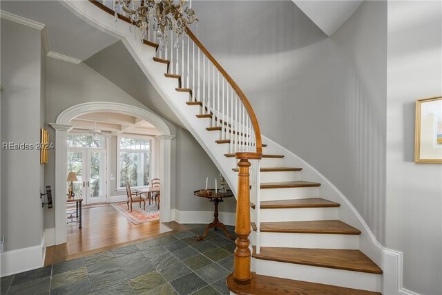 staircase featuring crown molding and french doors