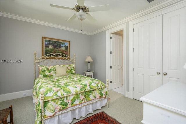 carpeted bedroom featuring crown molding, a closet, and ceiling fan