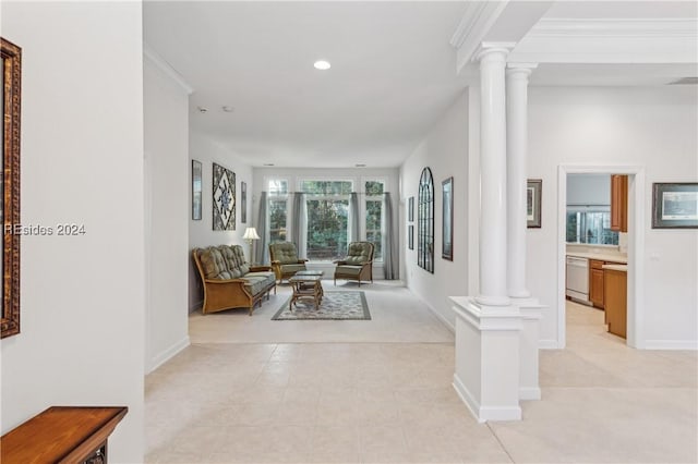 hall with crown molding, light colored carpet, and ornate columns