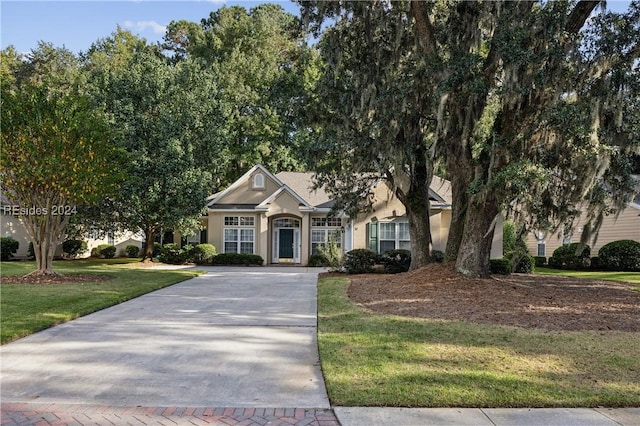 view of property hidden behind natural elements featuring a front yard