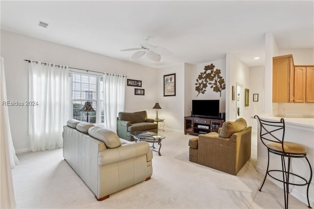 carpeted living room with ceiling fan