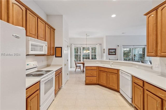 kitchen with a notable chandelier, sink, white appliances, and decorative light fixtures