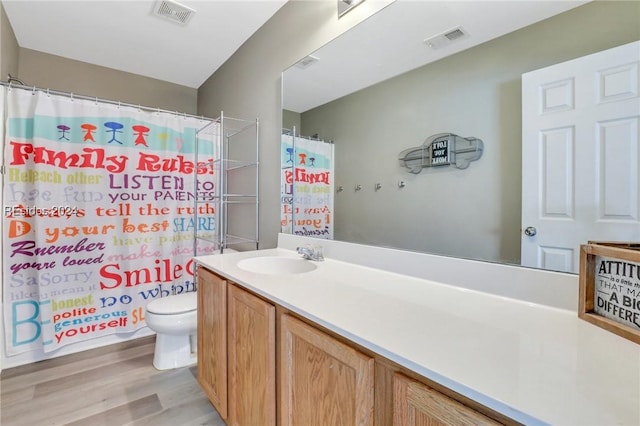 bathroom with vanity, hardwood / wood-style floors, toilet, and walk in shower