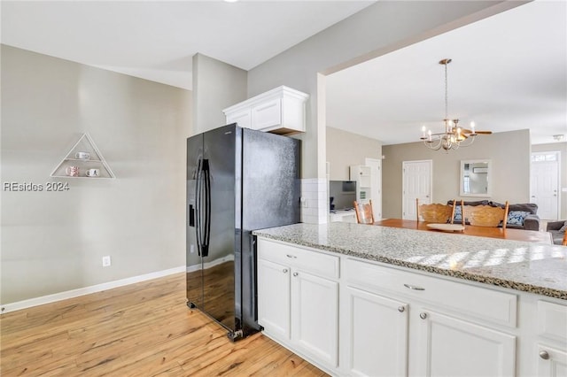 kitchen featuring white cabinetry, black fridge with ice dispenser, light stone countertops, and light hardwood / wood-style flooring